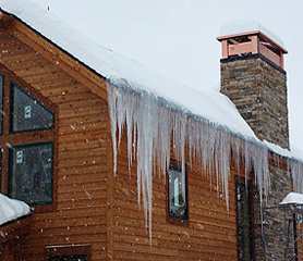 Steep roof with icicles in need of a roof deicing system