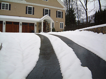 Asphalt heated driveway with tire track configuration.
